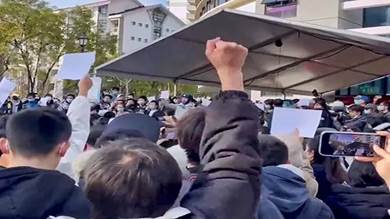محتجون يرفعون أوراقاً بيضاء على قيود كورونا في جامعة تسينجهوا في بكين، الصين